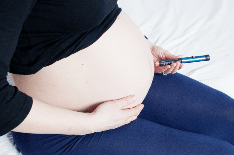 Pregnant woman injecting herself with insulin for gestational diabetes
